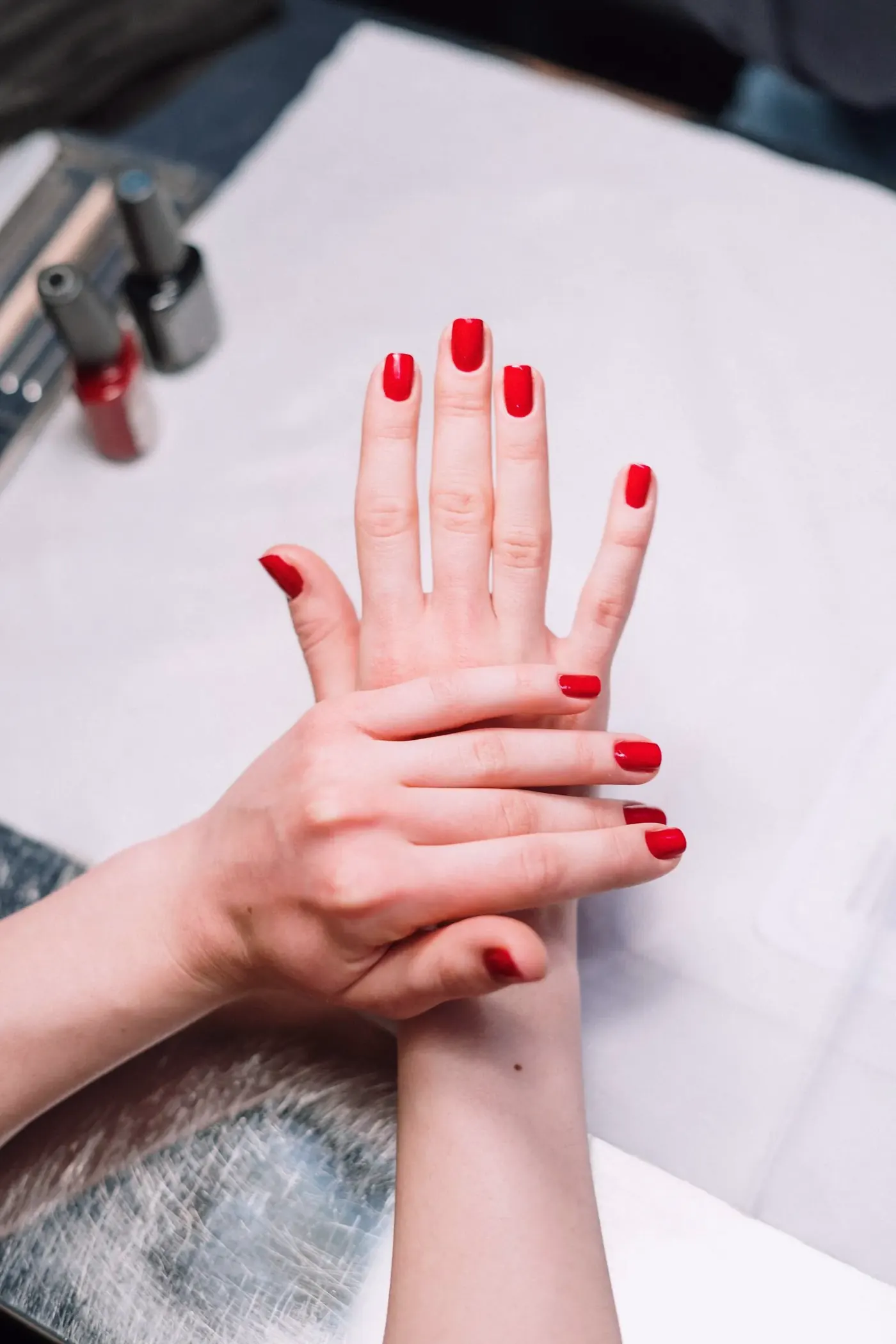 Hands showing a fresh glossy red manicure