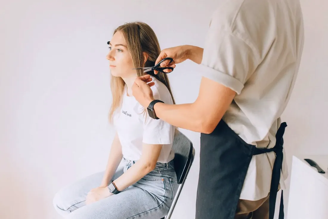 Stylist cutting a client hair in a salon chair