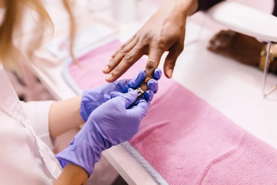 Nail technician working on a client hand at the table